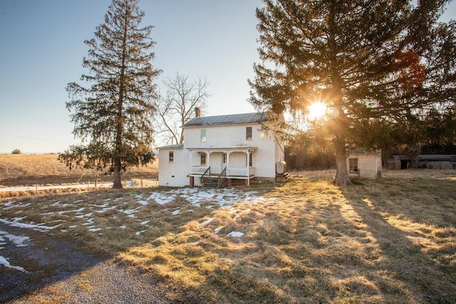 rear view of property with a storage shed