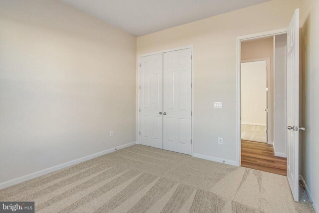 unfurnished bedroom with a closet and carpet flooring