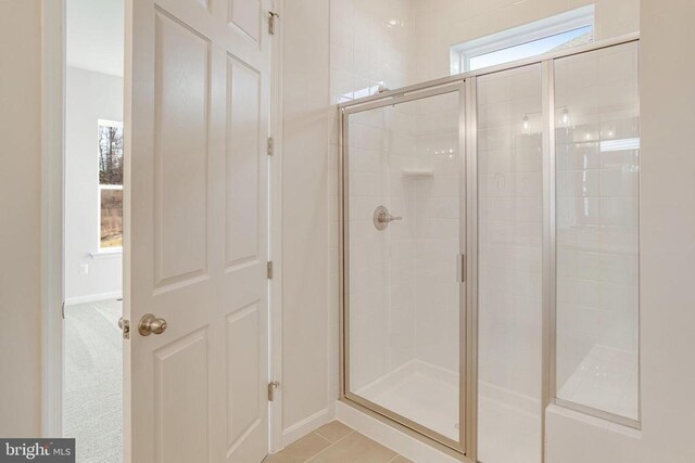 bathroom featuring a shower with door and tile patterned floors