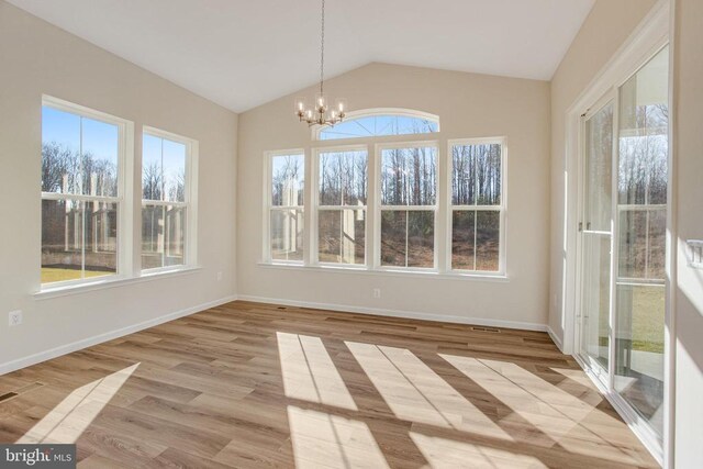 unfurnished sunroom with lofted ceiling, a notable chandelier, and a wealth of natural light