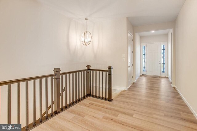 corridor featuring hardwood / wood-style floors and a notable chandelier