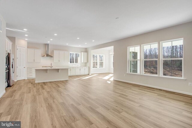 unfurnished living room featuring sink and light hardwood / wood-style floors