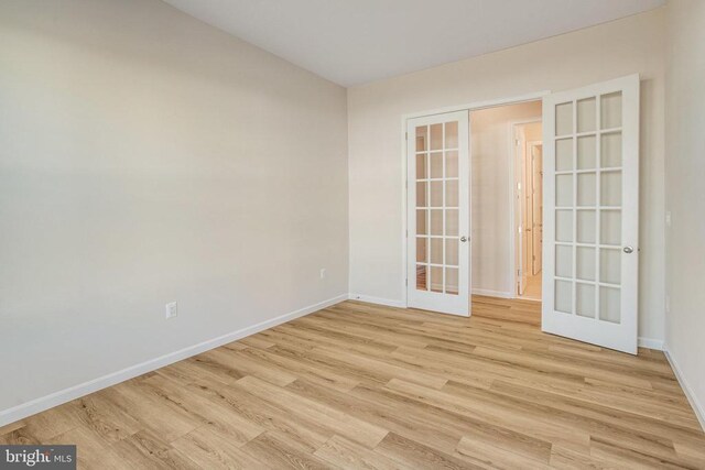 empty room featuring french doors and light wood-type flooring