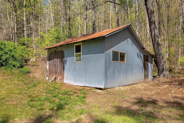 view of outbuilding with a wooded view and an outdoor structure