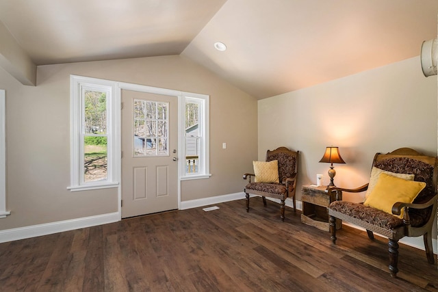 sitting room with baseboards, vaulted ceiling, and dark wood-type flooring