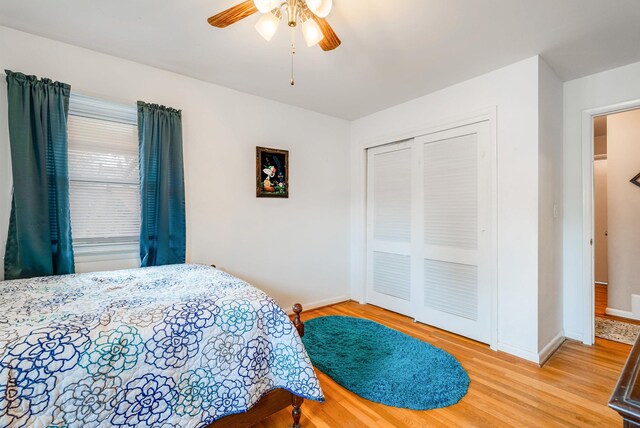 bedroom with wood-type flooring, ceiling fan, and a closet