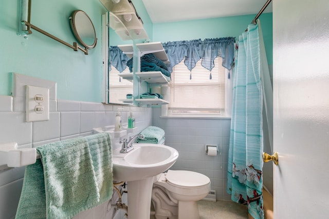 bathroom with sink, tile walls, curtained shower, and toilet