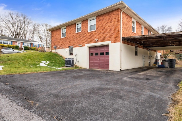 view of side of home featuring a garage, a yard, and central AC