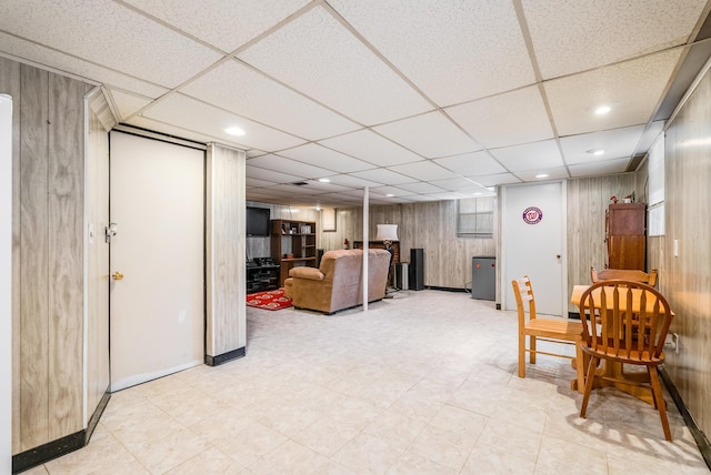 living room with wooden walls and a drop ceiling