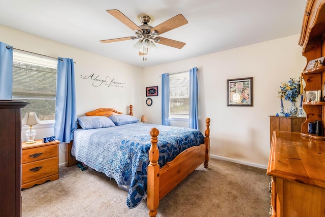 carpeted bedroom featuring ceiling fan and multiple windows