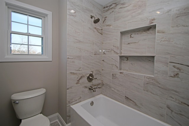 bathroom with toilet and tiled shower / bath combo