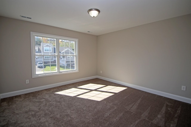 empty room featuring dark colored carpet