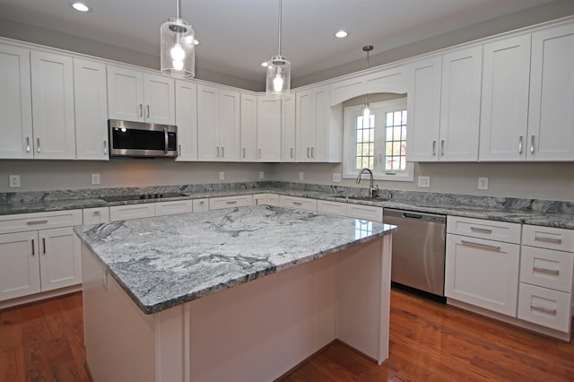 kitchen featuring sink, dark wood-type flooring, appliances with stainless steel finishes, white cabinets, and a kitchen island