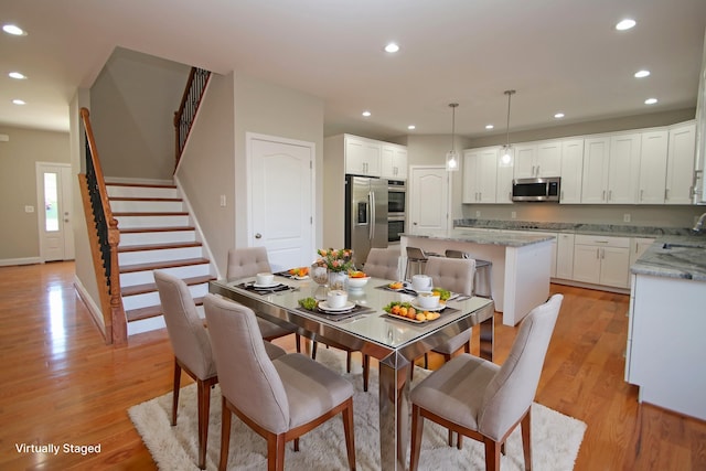 dining room featuring sink and light wood-type flooring