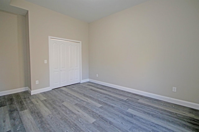 unfurnished bedroom featuring a closet and dark hardwood / wood-style floors