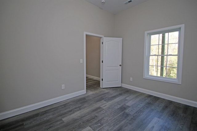 empty room with dark hardwood / wood-style flooring