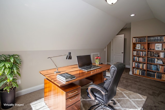 home office with lofted ceiling and dark carpet