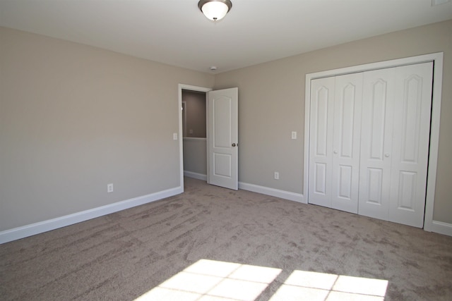 unfurnished bedroom with light colored carpet and a closet