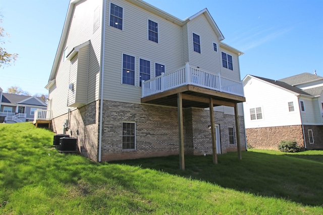 rear view of property with a wooden deck and a lawn