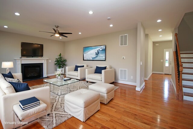 living room with light hardwood / wood-style floors and ceiling fan