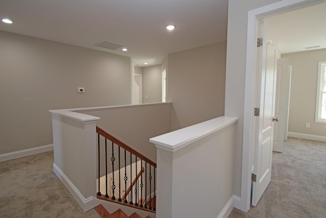 hall with light colored carpet