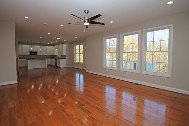 unfurnished living room featuring hardwood / wood-style floors and ceiling fan