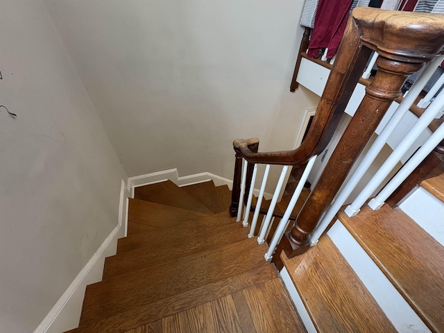 staircase featuring baseboards and wood finished floors