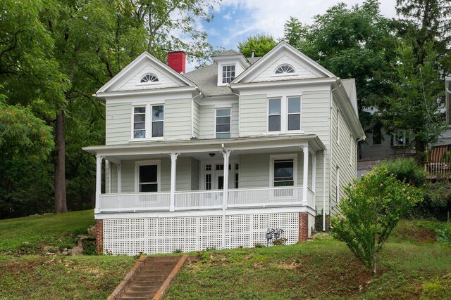 greek revival inspired property with a front yard and covered porch