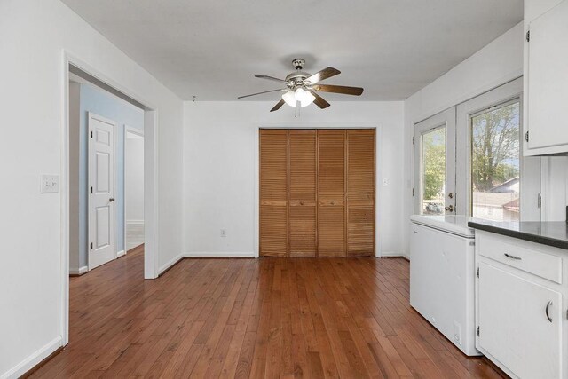 unfurnished bedroom with wood-type flooring, baseboards, and a closet