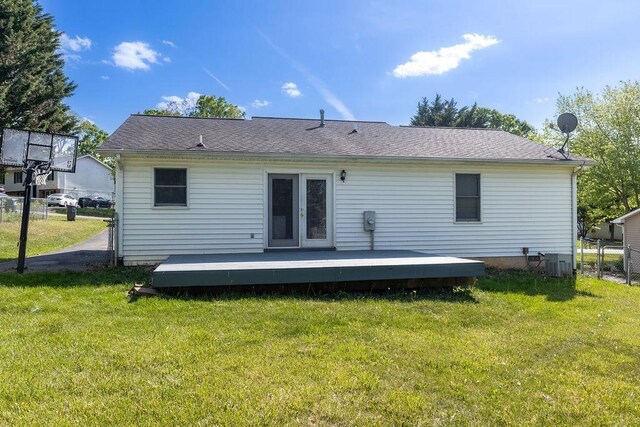 back of house featuring fence, french doors, a wooden deck, central AC unit, and a lawn
