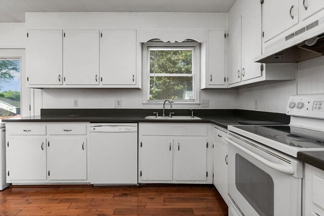 kitchen with a sink, under cabinet range hood, a wealth of natural light, and white appliances