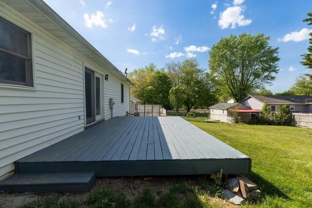 wooden terrace featuring a lawn and fence