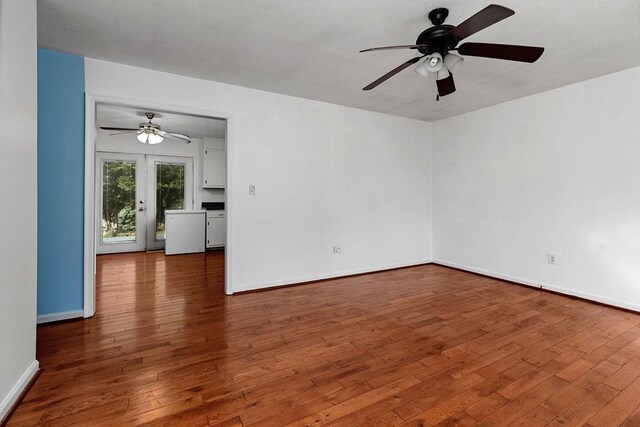 spare room featuring baseboards, a ceiling fan, and hardwood / wood-style flooring