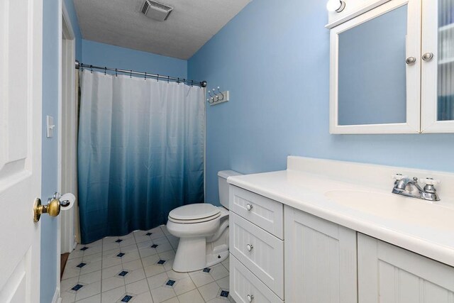 bathroom featuring tile patterned flooring, vanity, toilet, a shower with curtain, and visible vents