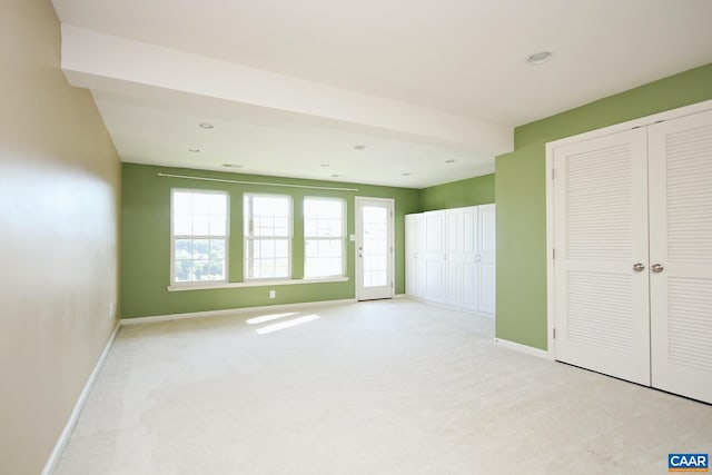 unfurnished bedroom with baseboards, recessed lighting, a closet, and light colored carpet