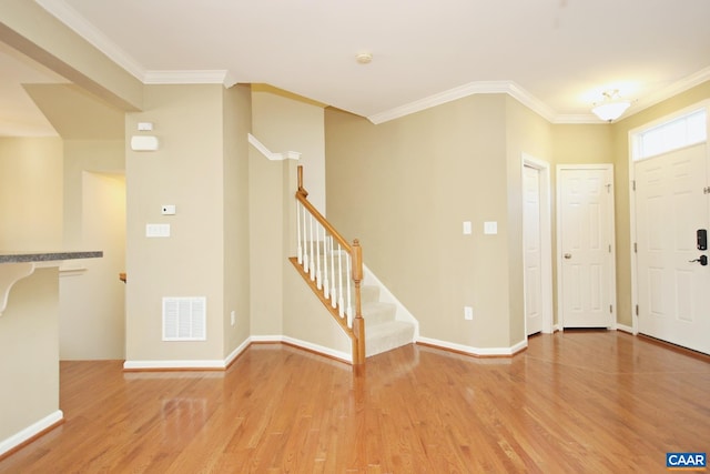 entrance foyer with light wood-style floors, stairway, visible vents, and ornamental molding