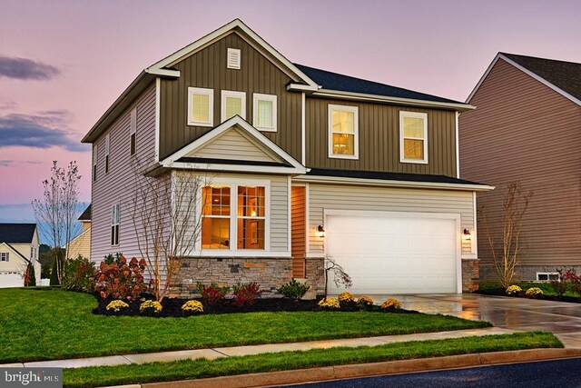 craftsman inspired home featuring a garage and a yard