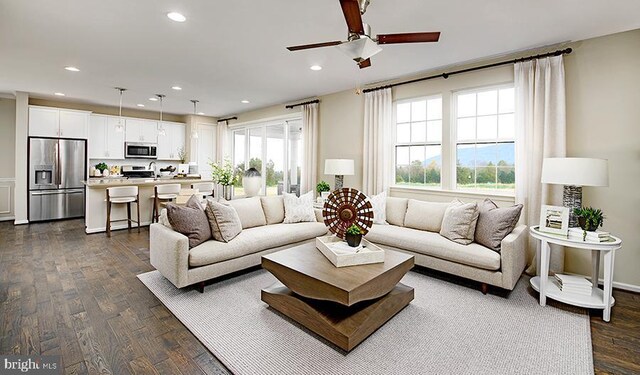 living room with ceiling fan and dark hardwood / wood-style flooring