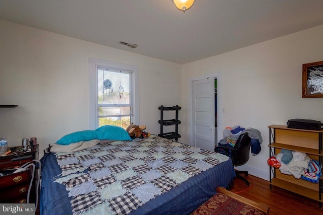 bedroom with dark hardwood / wood-style floors