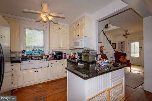 kitchen with ceiling fan, appliances with stainless steel finishes, sink, and dark hardwood / wood-style floors