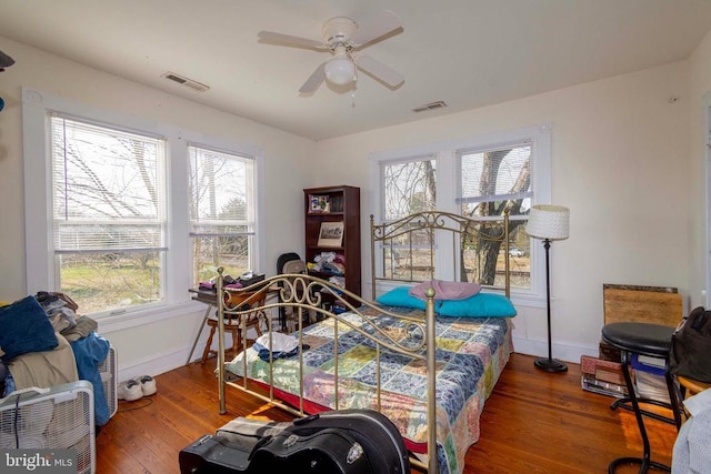 bedroom with dark wood-type flooring, ceiling fan, and multiple windows