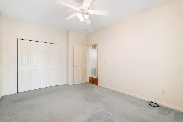 unfurnished bedroom featuring light colored carpet, a closet, and ceiling fan