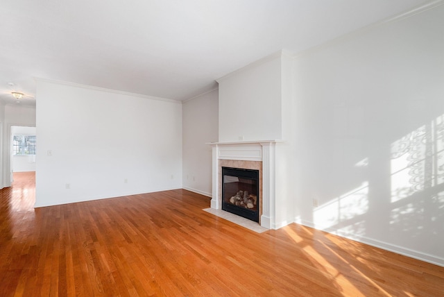 unfurnished living room with crown molding, a fireplace, and light hardwood / wood-style floors