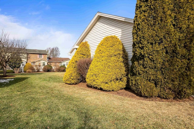 view of side of home with a yard