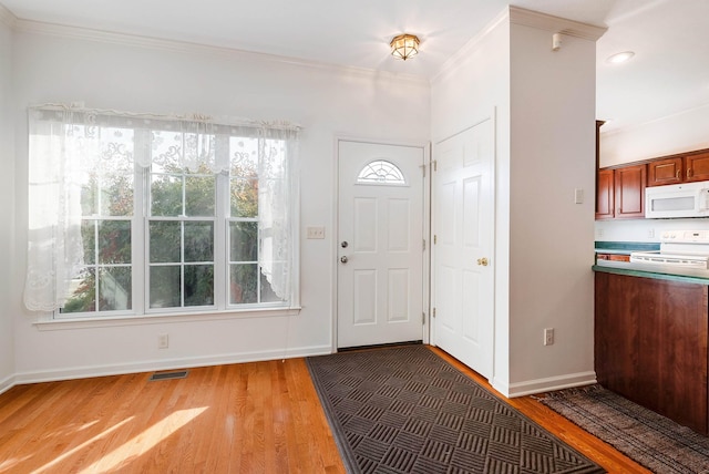 foyer entrance featuring crown molding and hardwood / wood-style floors