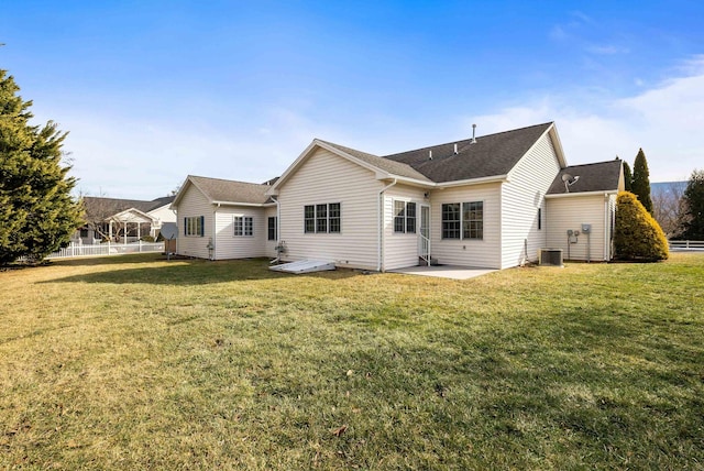 back of house with central AC, a lawn, and a patio