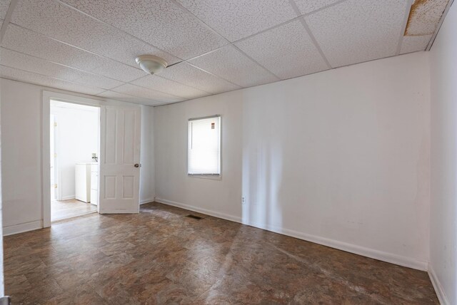 spare room with washer / clothes dryer and a paneled ceiling