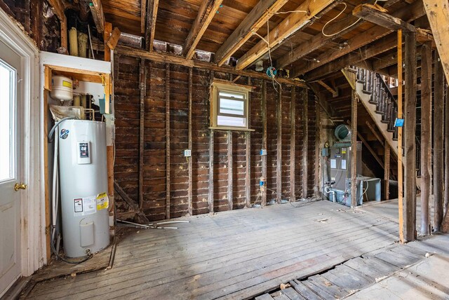 unfinished attic featuring water heater