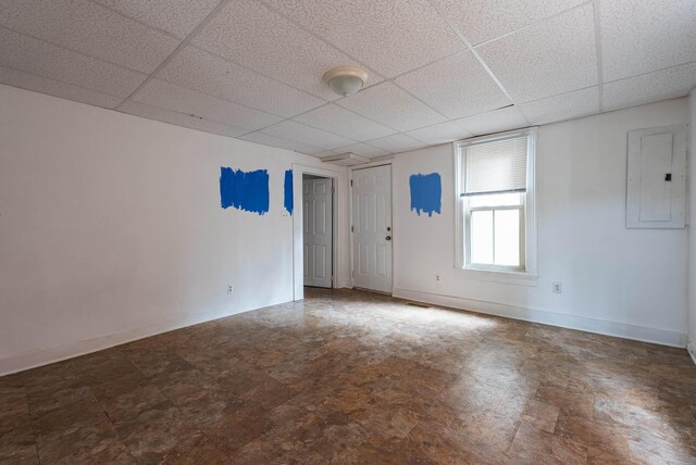 empty room with a paneled ceiling and electric panel