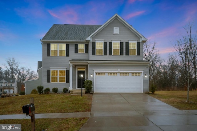 view of front of property featuring a yard and a garage